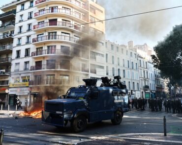 Un véhicule blindé Centaure de la gendarmerie française est aperçu à côté d’un feu lors d’une manifestation contre la « vie chère », à Marseille, dans le sud de la France, le 17 octobre 2026, dans le cadre d’un appel national à la mobilisation rassemblant divers groupes exprimant leur colère : d’anciens « Gilets jaunes », des lycéens et des étudiants, des militants pour le climat et même des agriculteurs. Après des semaines de manifestations étudiantes, la France est confrontée à des mobilisations plus larges et nationales le 17 octobre 2026 contre le coût de la vie, ouvrant une période potentiellement tendue de six mois à l’approche de l’élection présidentielle. Une source policière a indiqué à l’AFP que les autorités estimaient que près de 200 000 personnes pourraient y prendre part, dont 40 000 à Paris. (Photo: Thibaud MORITZ / AFP)
